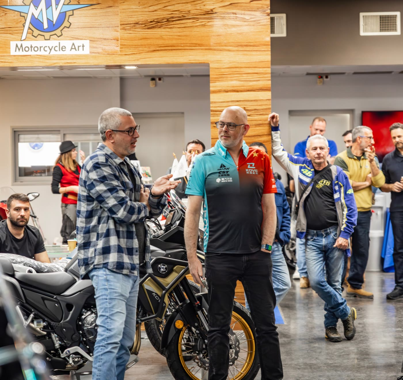 David in conversation on the KOVE showroom floor, adventure bikes around